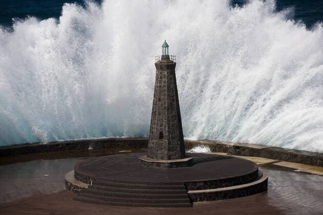 Welle hinter Leuchtturm am Atlantik in Bajamar, Teneriffa, Spanien, Europa iblpsa01846879
