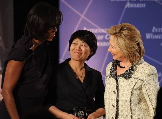 Secretary of State Hillary Rodham Clinton (R) and First Lady Michelle Obama (L) give an award to China s Jianmei Guo during the International Women of Courage Awards ceremony at the State Department in Washington on March 8, 2011.  WAP2011030826