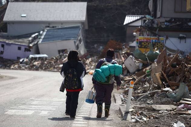(110314) -- OFUNATO, March 14, 2011 (Xinhua) -- Two residents walk along the road near the ruins in Ofunato city of Japan s northeastern Iwate Prefecture, March 14, 2011. (Xinhua Cheong Kam Ka) (zyw) JAPAN-OFUNATO-QUAKE 