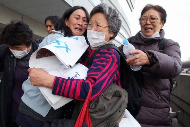 March 19th 2011 - Refugees from Futaba-cho, Fukushima - which was devastated by The 2011 Tohoku earthquake and tsunami on March 11th - arrive at Saitama Super Arena in Saitama City Japan where they will be housed for the forseeable future. Many had spent the past week in temporary shelters without adequate supplies and heat. Volunteers awaited to help foreigners who didn t understand Japanese and there were some tearful reunions. (The lady pictured wearing a mask was waiting to see her relative). As well as being destoyed by the tsunami, Futaba-cho was also just outside the nuclear exclusion zone and the refugees were glad to be abe to move away. (Photo - Yusuke Nakanishi Aflo)  ( aflo1090_110319_0202)