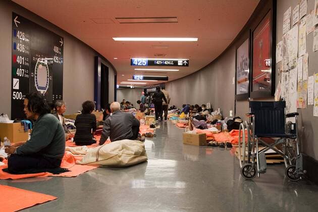 Saitama, Japan - A photo made available on March 22, 2011 shows evacuees from Fukushima along the hallways at Saitama Super Arena, a temporary shelter in Saitama, north of Tokyo. Thousands of residents from Fukushima evacuated their town as high levels of radiation continued to be a high risk from the quake-hit nuclear plant.  (XJRB-EvacueesatSaitamaSuperArena011)
