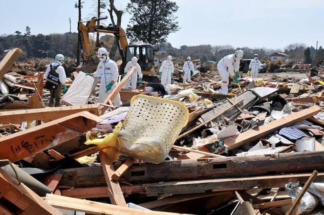 Japanese police wearing chemical protection suit search for victims inside the 20 kilometer radius around the Fukushima Dai-ichi nuclear power plant in Minamisoma, Fukushima prefecture, Japan, on April 7, 2011.  TKP2011041509