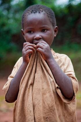 IMAGO Creative: Hunger ein kleines Maedchen kaut auf seinem T-Shirt, Burundi, Gitega little girl chewing her shirt, Burundi, Gitega BLWS257268