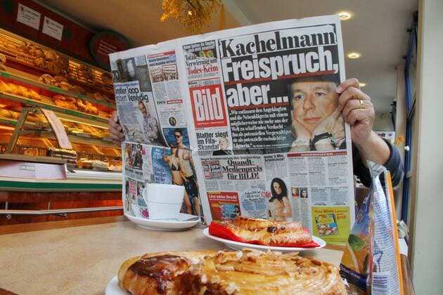 01.06.2011 Mann liest Bild Zeitung , Thema Freispruch Kachelmann in einer Konditorei in Waldshut, Deutschland 
