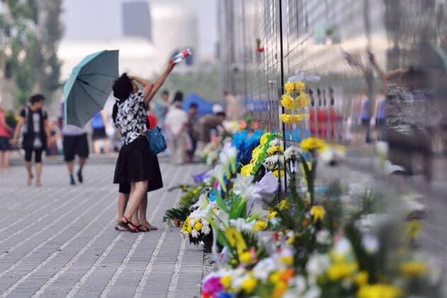 (110728) -- TANGSHAN, July 28, 2011 (Xinhua) -- Flowers are laid at a memorial wall in Tangshan, north China s Hebei Province, July 28, 2011. People from all walks of life came to a memorial park Thursday in Tangshan to commemorate the 35th anniversary of the Tangshan earthquake happened in 1976. (Xinhua Gao Wei)(mcg) CHINA-TANGSHAN-EARTHQUAKE-COMMEMORATION (CN) 