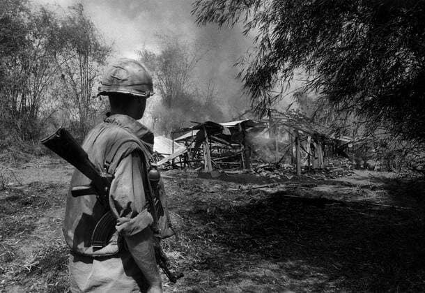 IMAGO History, Vietnamkrieg: 1955-1975 Vietnam war: An American soldier in front of the burning remains of one of the houses in Phu Lam. After the fires died down, he and one of his comrades were to go through the village to make sure no Viet Cong fighters were concealed in tunnels under the houses. 1968 Mono Print !AUFNAHMEDATUM GESCHÄTZT! UnitedArchives0785327