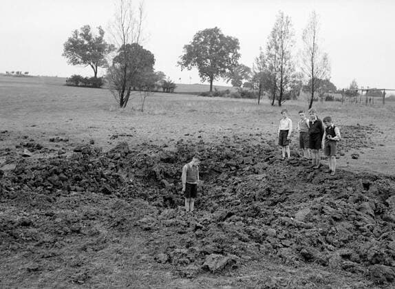 Boys in the crater caused by a 7kg bomb on South Herts Golf Course - 1940 ©TopFoto Mono Negative !AUFNAHMEDATUM GESCHÄTZT! UnitedArchives1198879