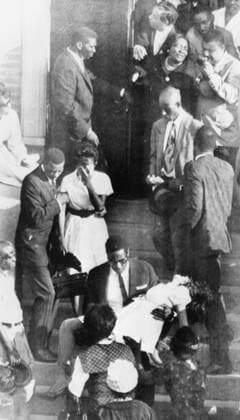 IMAGO History, U.S. Bürgerrechtsbewegung: 1954-1968 Birmingham , Alabama , The dramatic scene outside the 16th Street Baptist Church as members of the families of three of the four black girls killed in last Sunday s bombing of the church , are brought screaming from the church during yesterday s funeral service . The woman in white (foreground) fainted and had to be carried bodily from the church . 19th September 1963 Mono Negative !AUFNAHMEDATUM GESCHÄTZT! UnitedArchives1215245