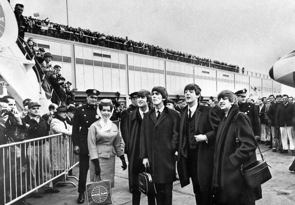 The Beatles left to right - John Lennon , George Harrison , Paul McCartney and Ringo Starr - face enthusiastic fans as they are pictured at John F Kennedy International aiport in New York on their arrival 7th February 1964 Mono Negative !AUFNAHMEDATUM GESCHÄTZT! UnitedArchives1246114