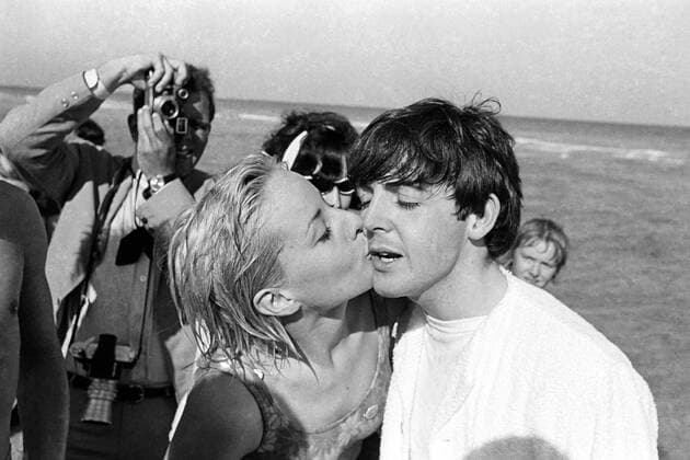 A blond American teenager plonks a hearty kiss on the cheek of her idol , Beatle Paul McCartney , as he and his fellow Beatles were cornered on a beach in Miami , Florida . The Fab Four have taken such a like to the sunny climes of Miami that they have extended their stay here . 15th February , 1964 Mono Negative !AUFNAHMEDATUM GESCHÄTZT! UnitedArchives1247817