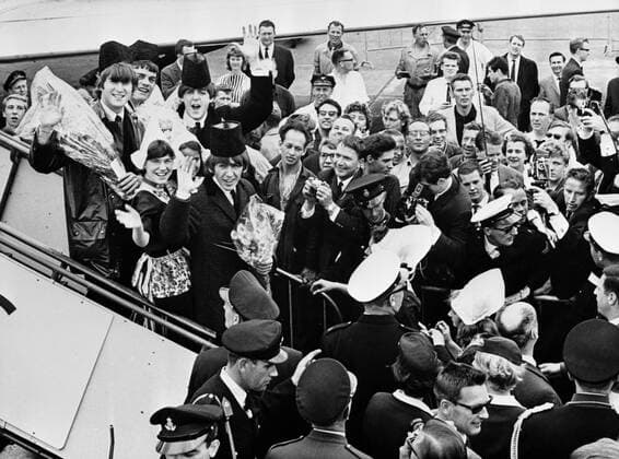 The Beatles wearing traditional Volendam Dutch hats on their arrival in Amsterdam airport. Shown on the aircraft steps are (Left to right) John Lennon ; replacement drummer Jimmy Nicol ; Paul McCartney and George Harrison 8th June 1964 Mono Negative !AUFNAHMEDATUM GESCHÄTZT! UnitedArchives1247993