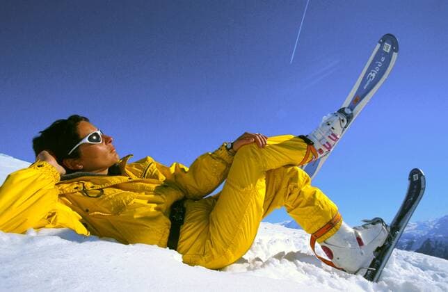 IMAGO Creative: Wintersport, Mode Skilaeuferin liegt im Schnee, macht Pause, geniesst die Sonne, traegt snowblades female skier lying in snow, making pause, enjoying the sun, wearing snowblades BLW036789