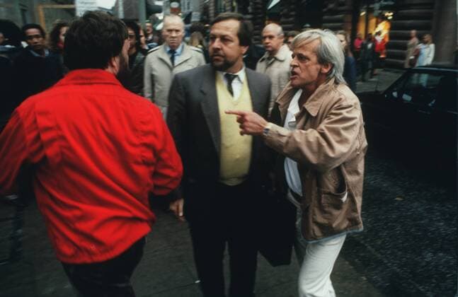 Klaus Kinski (re., Schauspieler) 10 85 vZ Mann TV Fernsehen Schauspiel Film Kino grauhaarig leger Jacke Hemd stehend draußen Menschen Fußgängerzone Geschäft Straße Haus Gebäude Streit Schlägerei halb quer Gespräch Farbnegativ Internegativ von Bild Nummer 372167