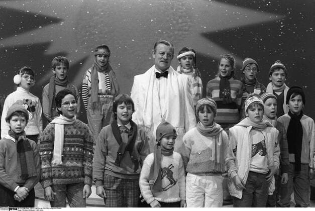 Roger Whittaker (Sänger) 12 85 stroe Roger Whittaker mit einem Kinderchor bei Wetten, dass...? am 14. Dezember 1985 in Hannover Mann Brite britisch Musik Lied Lieder deutsche Schlager Schlagersänger Liedermacher Kunstpfeifer Pfeifer Gesang Schlagerstar kurzhaarig kurze Haare Schnäuzer Schnauzbart Bart Oberlippenbart seriös festlich feierlich Anzug Hemd Jackett Fliege Schal stehen stehend lächeln lächelnd singen singend Auftritt Fernsehauftritt auftreten auftretend Bühne Kinder Kinderchor Chor Wintersachen Schals Mützen Weihnachten Weihnachtslieder Christmas-Songs Fernsehen Fernsehsendung Sendung TV TV-Show Show Fernsehshow Querformat quer Portrait halb sw