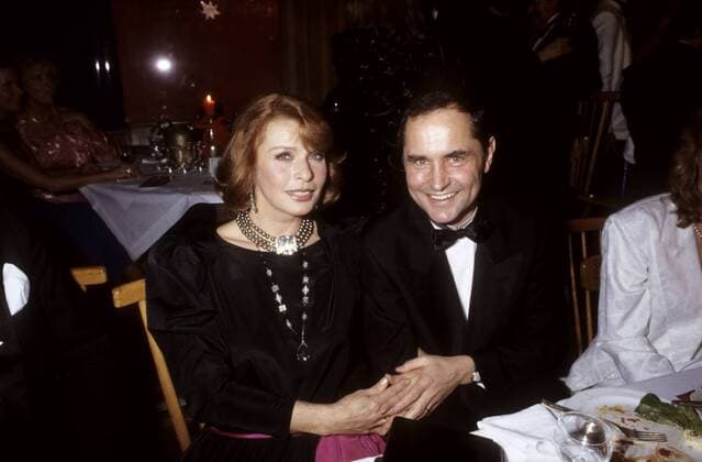 Senta Berger mit Michael Verhoeven 01 86 ru Senta Berger und Michael Verhoeven im Januar 1986 beim Mathäser Filmball Österreich Österreicherin österreichisch Frau TV Fernsehen Film Schauspiel Schauspielerin Moderation Moderatorin Sängerin Gesang Produzentin dunkelhaarig rothaarig langhaarig Kleid elegant festlich Schmuck Kette seriös Ehefrau Ehemann Ehepaar Deutschland deutsch Deutscher Regisseur Regie Anzug Smoking Fliege kurzhaarig Querformat quer halb sitzend lächelnd