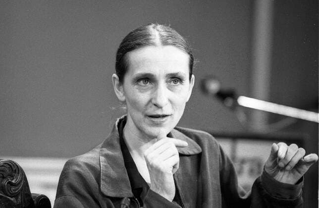 Pina Bausch Schwarz-Weiß-Negativ 07 86 - Frau Tänzerin Ballett Ballettdirektorin Choreographin Tanzszene Wuppertaler Ensemble Ausdruckstanz Tanz Sprechtheater Theater Tanztheater Künstlerin Kunst Kunstform Choreographie Choreographien Ballettszene leger sitzend sprechend gestikulierend Mikrophon Portrait quer Pina Philippine Bausch