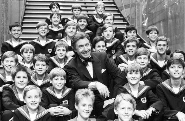 Peter Alexander mit den Wiener Sängerknaben 05 87 rag Fototermin im Mai 1987 während der Eröffnungs-Gala der Wiener Kongresshalle Austria Center , Wien Show Feier Soire e in Wien Mann Entertainment Entertainer Schauspieler Schauspiel Showmaster Sänger Gesang Musik TV Fernsehen Moderation Auftritt elegant Anzug Dreiteiler Fliege Sakko Österreich Österreicher quer halb sitzend Showtreppe Treppe Bühne Auftritt Kulisse gestikulierend Gestik Peter Alexander Neumayer