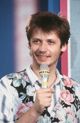 Günther Jauch (TV-Moderator) 09 87 ru Günther Jauch im September 1987 Deutschland deutsch Deutscher Mann Moderation TV Fernsehen Show Fernsehshow Journalismus Journalist dunkelhaarig kurzhaarig Hemd Weste leger unrasiert bärtig Dreitagebart german host presenter hoch Portrait lächelnd sprechend