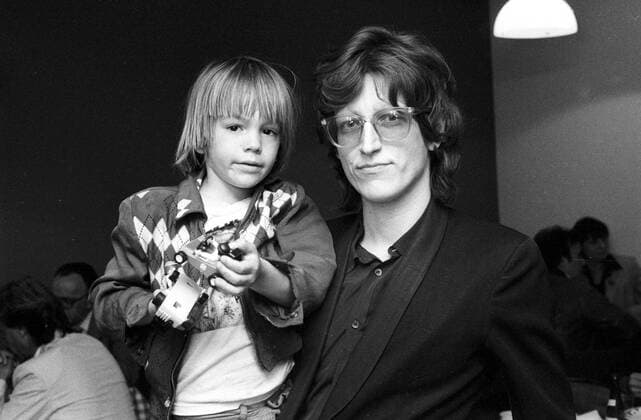 Gottfried Helnwein mit seinem Sohn Cyril 06 83 dec Gottfried Helnwein mit seinem Sohn Cyril im Juni 1983 am Rande von III nach 9 , RB drei neun 3 Talk Talkshow TV Fernsehen Österreich Österreicher österreichischer Mann Kunst Graphik Maler Illustrator Designer Graphiker Malerei Künstler Junge Kind austrian artist dunkelhaarig Brille leger quer halb Portrait haltend lächelnd sw