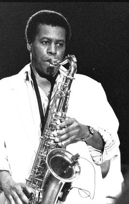 Wayne Shorter (Musiker) 07 88 hof Wayne Shorter bei einem Jazz-Festival im Juli 1988 Mann USA Amerika Amerikaner Musik Saxophon Saxophonist Tenorsaxophon Sopransaxophon Lyricon Jazzsaxophonist Komponist Jazz-Komponist Jazz Rock Jazz-Rock Band Weather Report dunkelhaarig kurzhaarig dunkelhäutig leger Hemd Bühne Auftritt auftreten auftretend stehen stehend Saxophon haltend in der Hand spielen spielend Uhr Armbanduhr Hochformat hoch Portrait halb sw