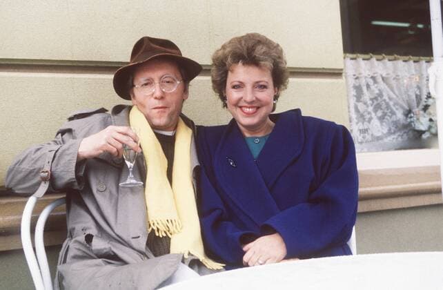 Marie-Luise Marjan mit Joachim Luger 11 88 - Frau Schauspiel TV Fernsehen Lindenstrasse Serie ARD leger sitzend nebeneinander draussen halb quer lächelnd Hauswand
