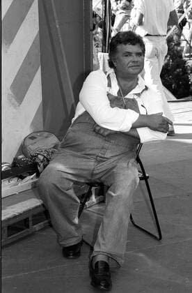 Klaus Dahlen (Schauspieler) 09 89 rag Klaus Dahlen im September 1989 während der IFA Internationale Funkausstellung in Berlin Schauspiel Schauspieler Film TV Fernsehen Deutscher deutsch Mann dunkelhaarig kurzhaarig lockig Locken Latzhose Hemd leger Jeans Latzjeans Brille umgehängt umhängend Stuhl Klappstuhl hoch Hochformat ganz sitzend sw s w schwarzweiß
