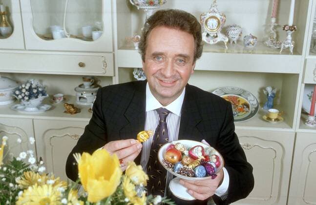 Günter Wewel (Sänger, Moderator) 02 90 hör Günter Wewel im Februar 1990 Deutschland deutsch Deutscher Mann TV Fernsehen Moderation Volksmusik Musik Operette Oper Bass Schlager german singer presenter host Süßes Süßigkeiten Naschen SChokolade Pralinen quer halb sitzend lächelnd exklusiv privat Homestory