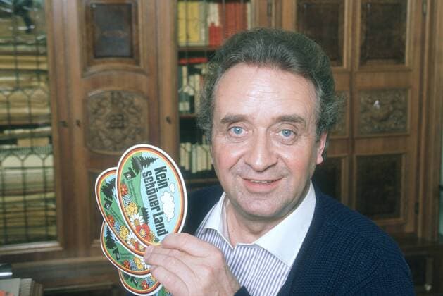 Günter Wewel (Sänger, Moderator) 02 90 hör Günter Wewel im Februar 1990 Deutschland deutsch Deutscher Mann TV Fernsehen Moderation Volksmusik Musik Operette Oper Bass Schlager german singer presenter host quer halb sitzend lächelnd Portrait Aufkleber Kein schöner Land exklusiv privat Homestory