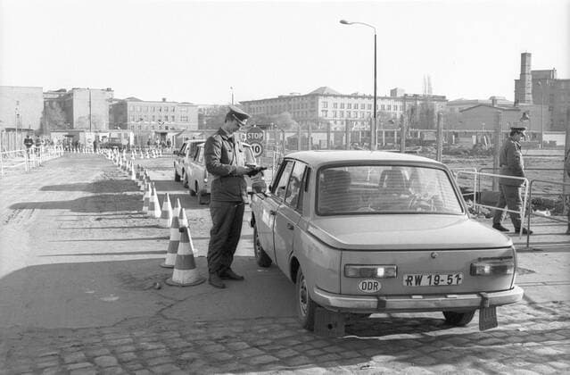 Feature Symbol: Berlin, November 1989 11 89 hör Provisorischer Grenzübergang in Berlin im November 1989 Deutschland Wiedervereinigung Einheit deutsche DDR Deutsche Demokratische Republik Bundesrepublik Deutschland BRD Hauptstadt geteilte Stadt Ostberlin Westberlin West Ost Grenze Grenzübergang Öffnung Mauer Berliner Sozialismus sozialistisch Wartburg Autos Trabis Trabanten Trabant Trabbis Trabbis Trabi Passanten Grenzübertritt Passkontrolle Kontrolle VoPo Volkspolizei Volkspolizist Polizei Polizist wall border gdr germany capital city reunification draußen quer