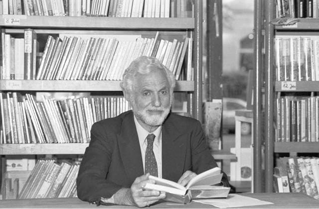 Carl Djerassi (Wissenschaftler) 05 91 Pop Carl Djerassi im Mai 1991 Mann Autor Wissenschaft Pille Anti Baby Verhütung Antibabypille Verhütungsmittel Erfinder Vater scientist author writer grauhaarig weißhaarig Bart seriös Krawatte Sakko Jackett quer halb sitzend lächelnd Buchhandlung Lesung Tisch sw