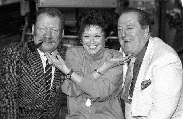 Heinz Eckner (re.) mit Lotti Krekel und Wolfgang Völz 02 92 te im Dezember 1990 in Tony, Tony noch einmal (SAT.1) Mann TV Fernsehen Schauspieler Schauspiel Schauspielerin Komik Komiker dunkelhaarig kurzhaarig seriös Anzug Krawatte Schlips Fernsehsendung Fernsehshow quer sitzend halb Pfeife rauchend