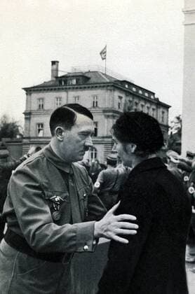 IMAGO History, Zweiter Weltkrieg: 1939 - 1945 Deutschland, Muenchen, 09.11.1934 Adolf Hitler ( 20. April 1889 in Braunau am Inn;   30. April 1945 in Berlin) war ein deutscher Politiker oesterreichischer Herkunft. Er war ab 29. Juli 1921 Vorsitzender der Nationalsozialistische Deutsche Arbeiterpartei (NSDAP), wurde am 30. Januar 1933 Reichskanzler und war von 1934 bis zu seinem Suizid 1945 unter der Bezeichnung ãFuehrer und ReichskanzlerÒ zugleich Regierungschef und Staatsoberhaupt des Deutschen Reiches, sowie ab 4. Februar 1938 Oberbefehlshaber der Wehrmacht. Foto: Adolf Hitler vor dem braunen Haus, bei der Wiederholung des historischen Marsches von 1923, wo der Hitler-Ludendorff-Putsch versuchte, am 09.November 1923 die Regierungsmacht an sich zu reißen, im Gespräch mit einer Parteigenossin Germany, Munich, 09.11.1934 Adolf Hitler (April 20, 1889 in Braunau am Inn,   30 April 1945 in Berlin) was a German politician of Austrian o
