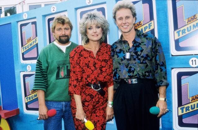 Sigi Harreis mit Jürgen von der Lippe (li.) und Klaus Eberhartinger 09 89 ru Sigi Harreis mit Jürgen von der Lippe (li.) und Klaus Eberhartinger im September 1989 während der IFA Internationale Funkausstellung in Berlin Deutschland deutsch Deutsche Frau TV Fernsehen Show Moderation Journalistin Journalismus Moderatorin Deutscher Österreicher österreichischer Mann Moderator Männer Moderatoren Sänger german austrian singer female host presenter hosts presenters quer halb stehend lächelnd posierend Pose Show Fernsehshow Kulisse Deko Siglinde Harreis-Langer Dannenmann