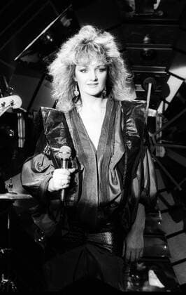 Bonnie Tyler (Sängerin) 01 86 scha Bonnie Tyler im WWF-Club im Januar 1986 Wales walisisch walisische Großbritannien englisch englische Gesang Rock Fernsehen Sendung Show TV Frau female singer english welsh hoch halb lächelnd blond Locken Mikrofon Lederjacke schwarz Bühne Auftritt sw
