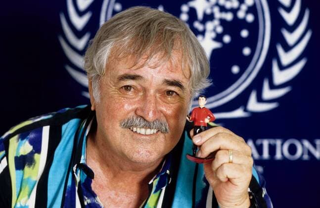 James Doohan ( Scotty , Raumschiff Enterprise) 07 95 her STAR TREK Schauspiel TV Fernsehen Kino Star Trek Mann grauhaarig Schnäuzer leger Hemd bunt quer Portrait Figur Scotty haltend zeigend lächelnd