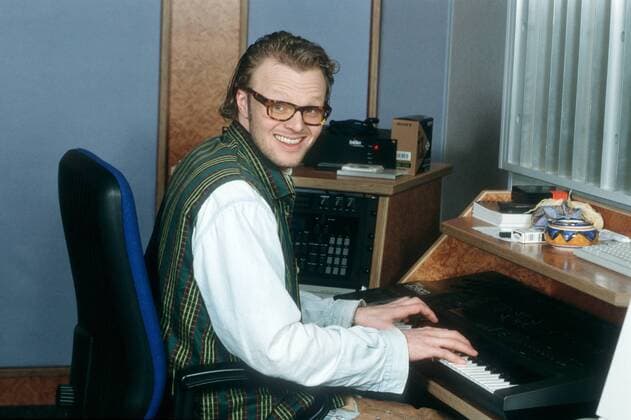 Stefan Raab 02 96 mo Mann TV Moderation Musik VIVA Unterhaltung dunkelhaarig Brille leger Hemd Weste quer halb sitzend Stuhl Instrument Keyboard spielend lächelnd