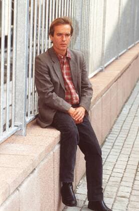 Martin Amis (Schriftsteller) 10 96 am Mann Literatur Schriftstellerei Autor England dunkelhaarig leger HEMD kariert Jackett draußen Hände sitzend Mauer neutral ganz hoch