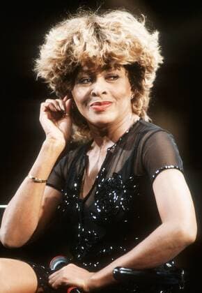 Tina Turner in Wetten, daß...? (ZDF) 11 96 pp Frau Musik Pop Gesang USA dunkelhäutig dunkelhaarig kurzhaarig Locken sexy leger Minikleid schwarz Auftritt Studio sitzend Mikrophon haltend Hand neutral halb hoch
