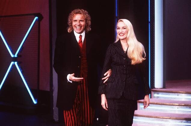 Thomas Gottschalk und Jerry Hall in Wetten, daß...? (ZDF) 02 97 her TV Fernsehen Film Show Moderation Studio Dekoration Kulisse seriös stehend Treppe Gespräch halb quer 22.02.97 in Münster