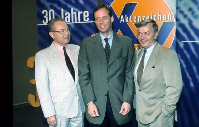 v.l.: Eduard Zimmermann, Dr. Butz Peters, Peter Nidetzky 07 97 kri TV Fernsehen Moderation Kriminalfall Mann seriös Studio Dekoration Kulisse Logo Aktenzeichen XY...ungelöst (ZDF) stehend halb quer Hemd Jackett Krawatte neutral