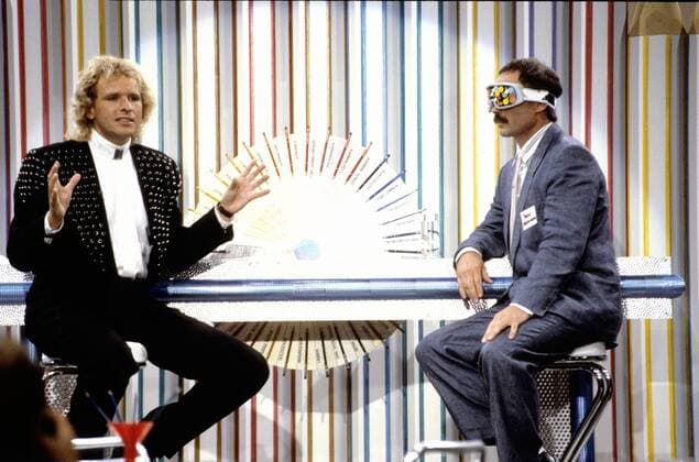 Buntstift -Wette: B. Fritz als T.Rautenberg & T.Gottschalk (l.) in Wetten, daß...? ZDF 9 88 hör TV Fernsehen Show Wette Studio Dekoration Kulisse sitzend Stift Mann seriös Tisch halb quer Gespräch Bernd am 03.09.88 Thomas Gottschalk Rautenberg