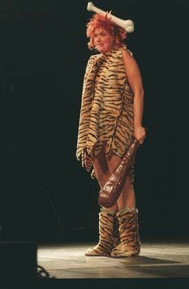 - Gaby Köster - Farbnegativ 09 98 thg Frau Schauspiel Komik Kabarett Comedy Auftritt Bühne Verkleidung Steinzeit Kleid Tiger Knochen Keule haltend stehend sprechend ganz hoch Die dümmste Praline der Welt