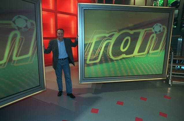 - Oliver Welke - Farbnegativ 04 98 her TV Fernsehen Moderation Sport Studio Dekoration Kulisse Logo Mann dunkelhaarig kurzhaarig leger Hemd Jackett stehend ganz quer lächelnd