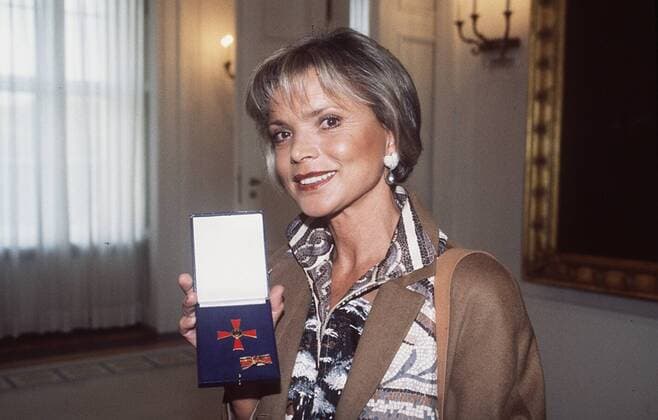 Uschi Glas mit Bundesverdienstkreuz 10 98 te Frau TV Fernsehen Schauspiel Schmuck Ohrring leger Blazer Medaille haltend stehend lächelnd halb quer