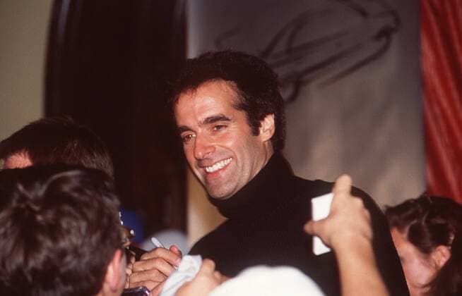 David Copperfield (Zauberer, Magier) 10 98 pp Mann Artisten Astrologie Effekte Medien Phantasie Show kurzhaarig dunkelhaarig leger stehend lächelnd halb quer autogrammegebend schreibend