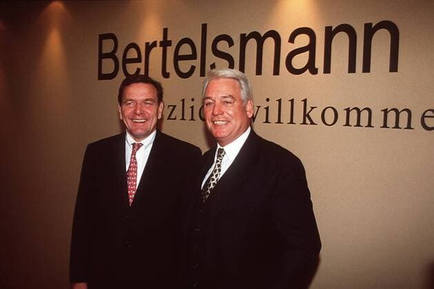 Dr. Mark Wössner mit Gerhard Schröder (li.) 10 98 thg Mann seriös Jackett Hemd Krawatte stehend Logo Bertelsmann halb quer lächelnd