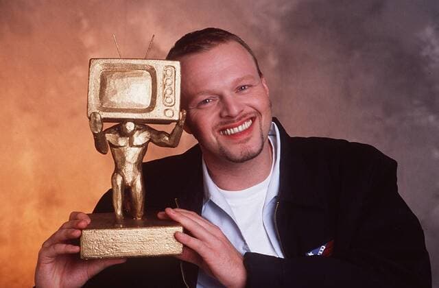 Stefan Raab mit dem Fernsehpreis Raab der Woche (ProSieben) 01 99 her Mann TV Moderation Musik VIVA Unterhaltung Produktion Gesang Pop TV total PRO 7 ProSieben Fernsehpreis Preis kurzhaarig Trophäe haltend lächelnd leger Shirt halb quer