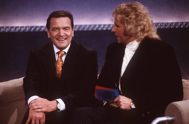 Wetten, daß...? (ZDF) Thomas Gottschalk (re.) mit Gerhard Schröder 02 99 thg TV Fernsehen Show Studio Dekoration Kulisse Moderation Gespräch sitzend angelehnt Hände lächelnd halb quer am 20.02.99 in Münster