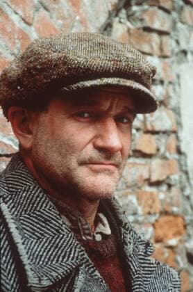 Robin Williams in Jakob der Lügner 08 99 teu Mann USA Amerika dunkelhaarig Schauspiel Kino Film Szene Filmszene Verkleidung Kostüm Mantel Fischgrätmuster Hemd alt Pullunder Baskenmütze stehend draußen Mauer Backstein kaputt Dreitagebart Portrait hoch ratlos traurig müde