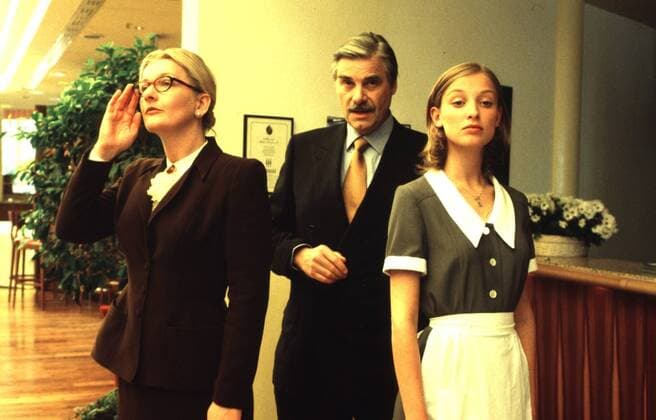 Vertrauen ist alles (ZDF) v.l.: S. Vester, P. Simonischek, A. M. Lara 10 99 ker TV Fernsehen Film Schauspiel Saskia Peter Alexandra Maria Szene Szenenfoto seriös Anzug Krawatte Kostüm Brille Hochsteckfrisur Schürze Uniform stehend Hotel Rezeption Blume halb quer Gespräch skeptisch nachdenklich gelangweilt